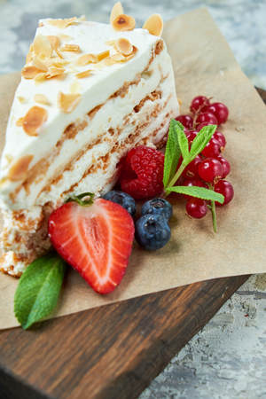 Strawberry meringue cake with almond petals, on newspaperの写真素材