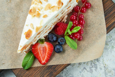 Strawberry meringue cake with almond petals, on newspaperの写真素材