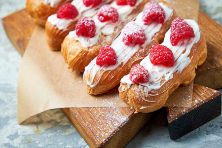 Cake eclair. Gray textured background. Beautiful serving dishes. Dessert. Food chain