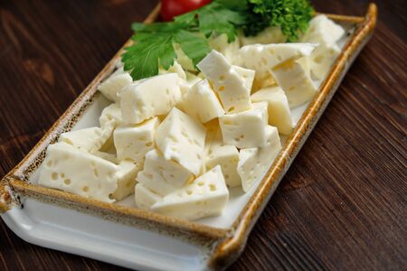 Beautiful table setting Cheese platter on a white plate on a dark background. Food styling.の写真素材