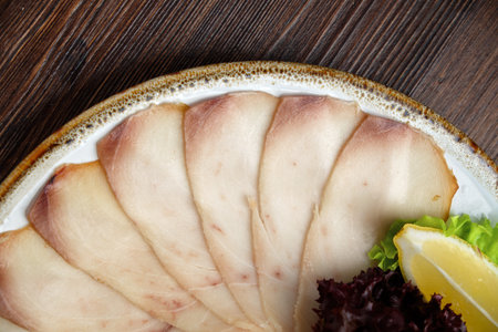 White and red fish sliced in thin slices on a brown wooden background. restaurant menu