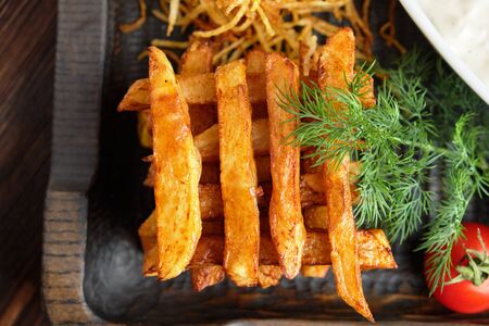 Hot appetizer on a wooden black plate on a dark wooden background. Restaurant menuの写真素材