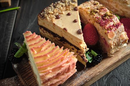 Different pieces of cakes on a wooden board . catering menuの写真素材