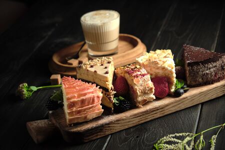 Different pieces of cakes on a wooden board . catering menuの写真素材