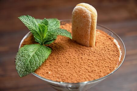 Tiramisu in a glass vase on a dark wooden background. catering menuの写真素材