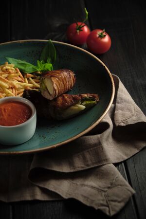 Meatloaf with potatoes straws with sauce on a blue plate on a dark wooden background. catering menuの写真素材