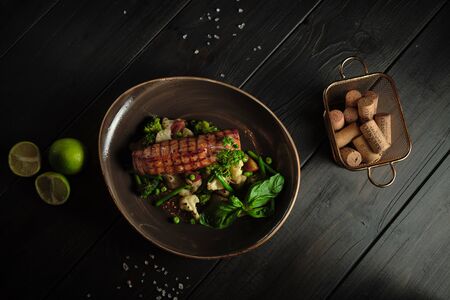 Grilled fish steak with broccoli and cauliflower on a brown plate on a dark wooden background. catering menuの写真素材