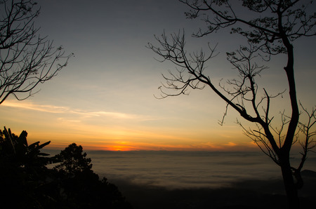 A lot of mist and sunrise behind the mountain at the northern Thailand.の写真素材