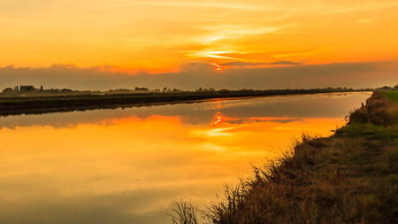 Beautiful golden sunset sky over riverの写真素材