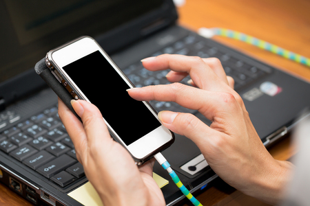 Hand use smartphone and computer laptop working from homeの写真素材