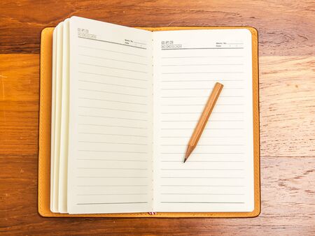 Top view blank note book with pencil on wooden tableの写真素材