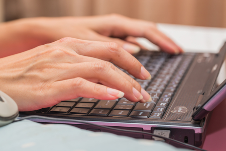 Hand using computer laptop PC in homeの写真素材