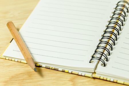 Pencil and open notebook on tableの写真素材