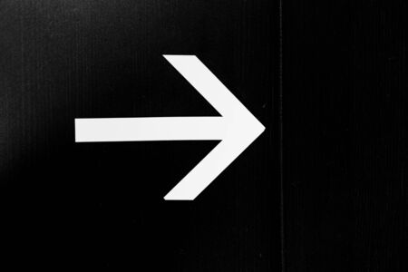 Arrow direction sign on blackの写真素材