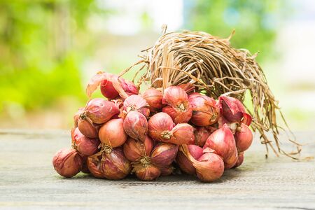 Red onions on wooden tableの写真素材