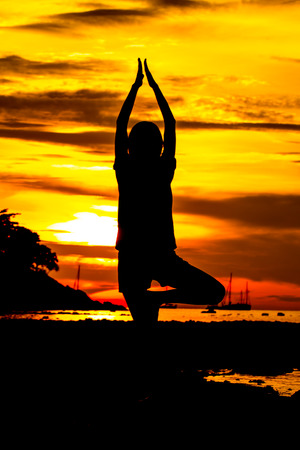 Silhouette yoga on sunset skyの写真素材