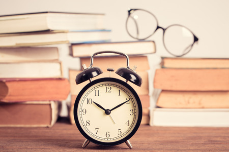 education concept. alarm clock on stacked old book backcgroundの写真素材