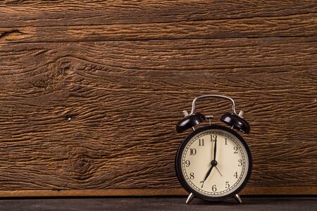 Vintage alarm clock on grunge wood backgroundの写真素材