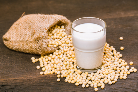 Soy milk and beans on wooden tableの写真素材