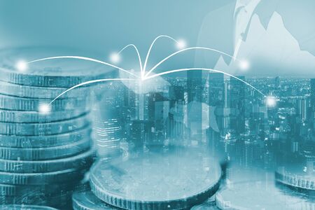 Double exposure money coins on city and business trading graphの写真素材