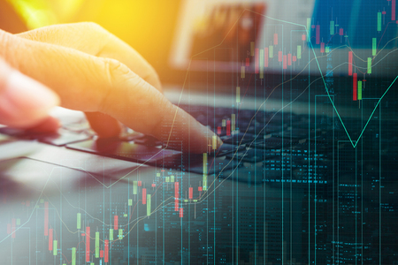 Hand use computer invest online on business trading graphの写真素材