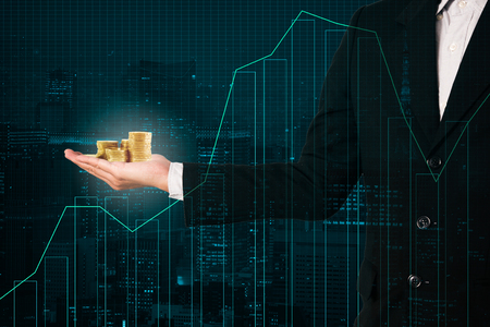 business man hold golden money coins on trading investment graphの写真素材