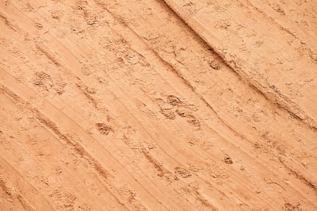 Traces of shoes and a road roller on yellow sand. Preparing for laying the road surface.の写真素材