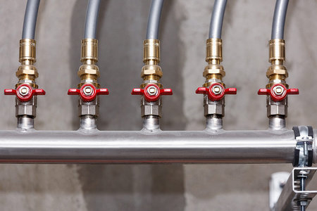 Water supply system node on the background of a concrete wall, close-up