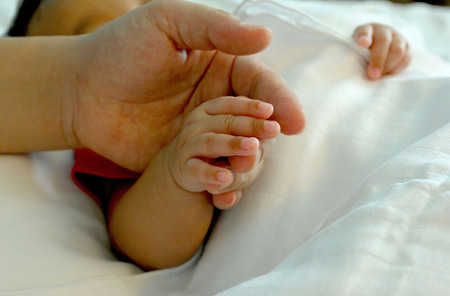 warmly touch, mom's hand with baby's handの写真素材