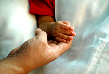 warmly touch, mom's hand with baby's handの写真素材