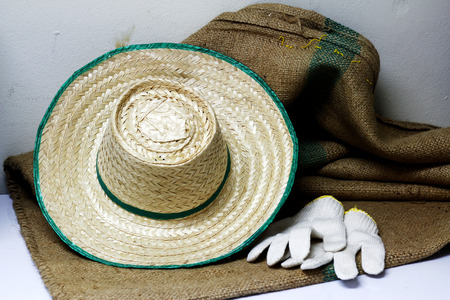 straw hat and glove with sack backgroundの写真素材