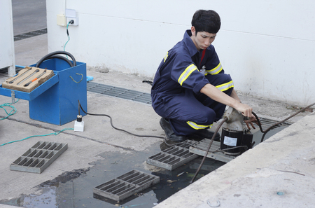 engineer used plumber's snake machine to remove clogs that obstruct in main pipeの写真素材
