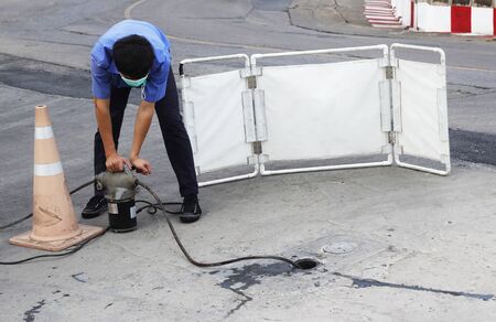 engineer used plumber's snake machine to remove clogs that obstruct in main pipeの写真素材