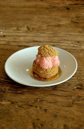 cupcake with strawberry cream on wooden table