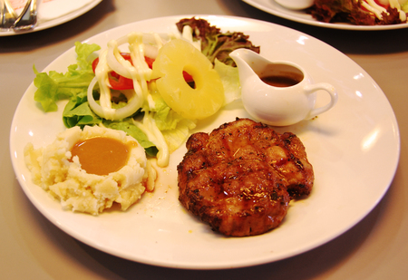 pork steak with mashed potato , gravy sauce and saladの写真素材