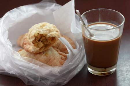 hot coffee thai style with curry puff on wooden tableの写真素材