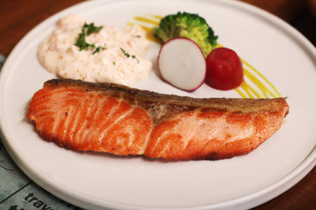 plate of grilled salmon steak with vegetables