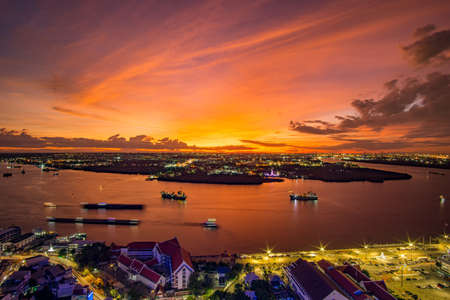 Bird's eye view of Samut Prakan, Thailand. Sunset over the Chao Phraya River, orange sky.の写真素材