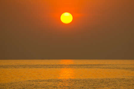 he sun fell in the evening. Shining golden color, reflecting the sea waterの写真素材