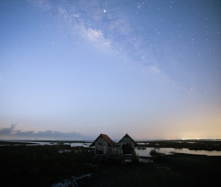 Milky Way early morning before sunrise, old abandoned house, red roof on open fieldの写真素材