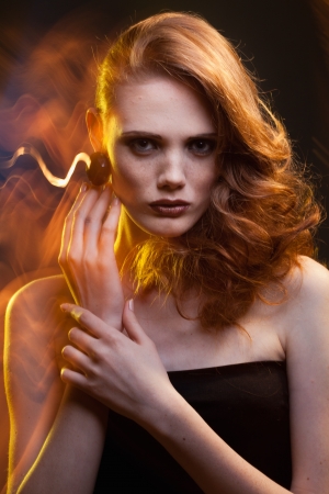 portrait of red-haired girl in a mixed lightの写真素材