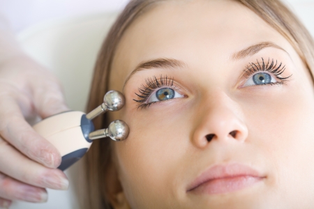 woman having a stimulating facial treatment from a therapistの写真素材
