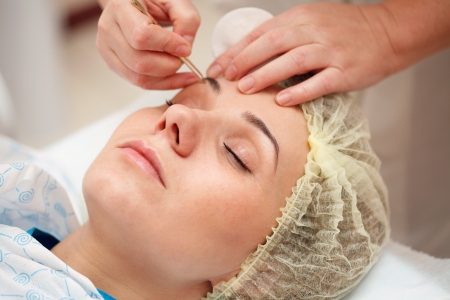 woman having a stimulating facial treatment from a therapistの写真素材