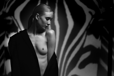Fashion art studio portrait of elegant naked lady with shadow on her bodyの写真素材
