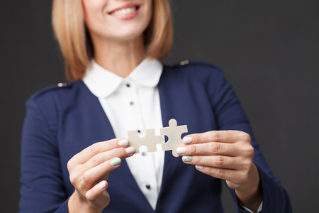 Problem solution concept flat.Man's hand places last detail of puzzle in jigsaw.の写真素材