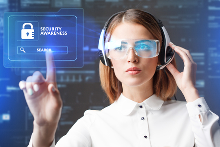 Business, Technology, Internet and network concept. Technology future. Young businesswoman working in virtual glasses, select the icon Security Awareness on the virtual display.の素材 [FY31084816596]