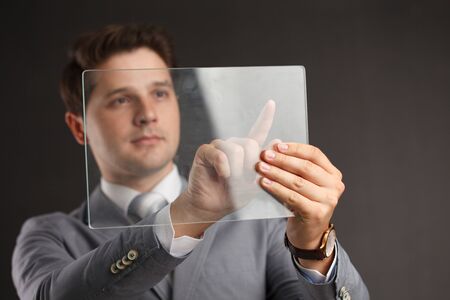 Business, Technology, Internet and network concept. Businessman working on the tablet of the future, select on the virtual displayの写真素材