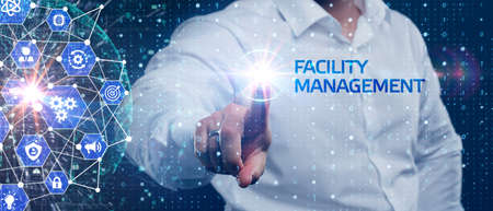 Business, Technology, Internet and network concept. Young businessman shows the word on the virtual display of the future: Facility managementの写真素材