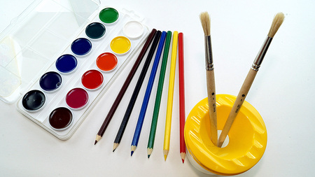 watercolors, colored pencils and brushes on a white backgroundの写真素材