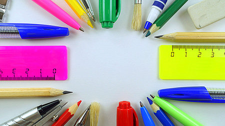 pens, pencils and rulers lined circle on a white background